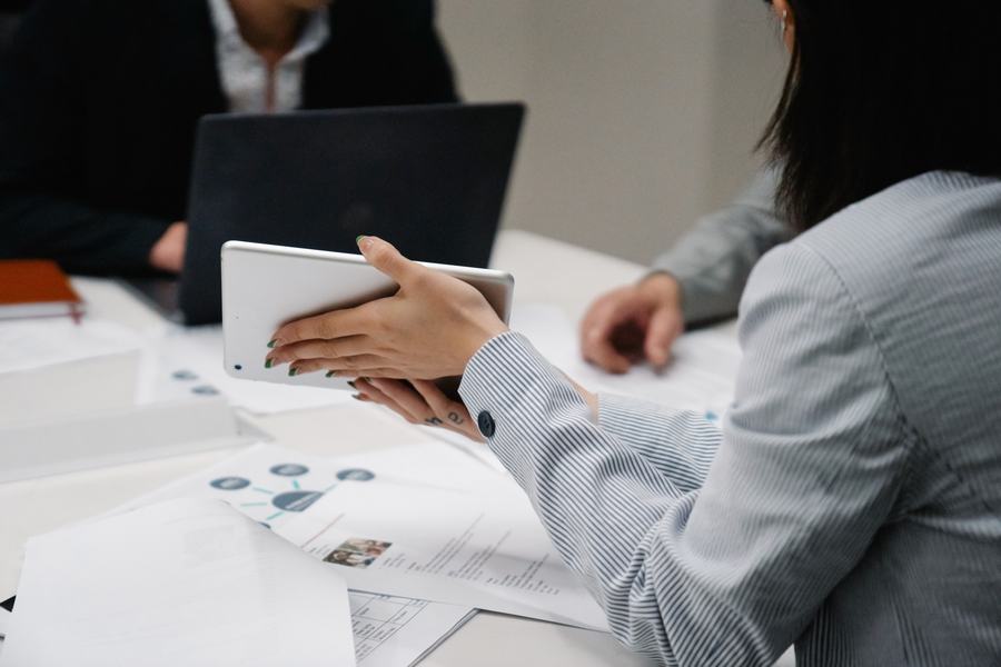 Tim sales menutup deal menggunakan tablet dan laptop